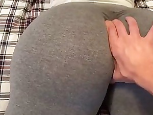 Ample butt brown-haired in yoga pants is giving a voluptuous footjob to one of her mates